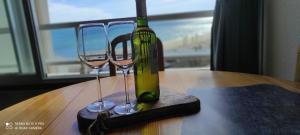 a bottle of wine and two wine glasses on a table at Appartement de vacances - Splendide vue sur mer, Parking privé in Le Barcarès