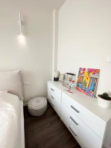 a white bedroom with a white dresser and a bed at New luxury furnished apartment - beach, Varna center & fast Wi-FI in Varna City