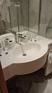 فندق أبراج نوازي  في مكة المكرمة: حمام مع حوض أبيض ومرآة