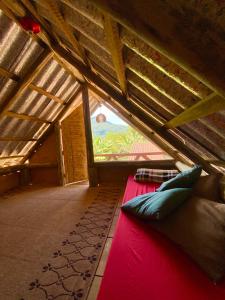 a room with a bed in a attic with a window at Greensoul Hospedagem in Ubatuba