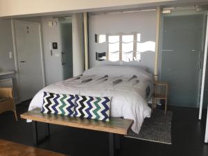 una camera con un grande letto e una panca di legno di Royal Zeezicht Oostende a Ostenda