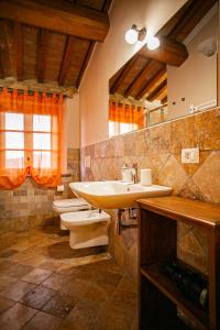 a bathroom with two toilets and a sink and a mirror at Agriturismo Fonte Belvedere in Collesalvetti