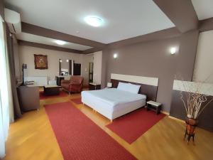 um quarto com uma cama branca e um tapete vermelho em Premier Hotel em Skopje