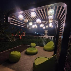 een patio met groene stoelen en 's nachts verlichting bij Lafayette Park Square Iloilo in Iloilo City