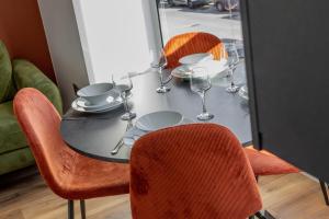 a black table with chairs and wine glasses on it at Eastside Capital Apartments in Belfast