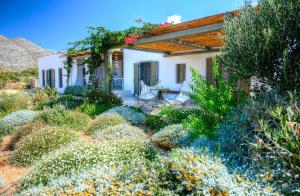 un jardín con una casa blanca con pérgola en Amorgos Villa Handras / Main villa, en Amorgós