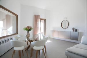 a white living room with a glass table and white chairs at Villa Allegra Luxury Holiday House in Salò