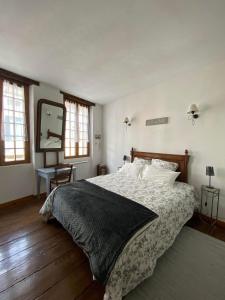 1 dormitorio con 1 cama grande y espejo en Gite de la Sauvetat, en Auvillar