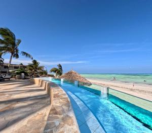 een uitzicht op het strand en het zwembad van het resort bij Zula Zanzibar in Paje