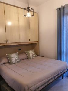 a bedroom with a large bed with a cabinet at Monolocale PIANO TERRA a pochi minuti dall'ospedale Sacro cuore in Negrar