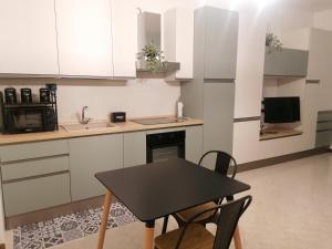 a kitchen with a black table and chairs in it at Monolocale PIANO TERRA a pochi minuti dall'ospedale Sacro cuore in Negrar