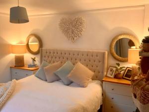 a bedroom with a bed with two mirrors on the wall at Romantic luxury Cottage right next to the ocean in Saint Abbs
