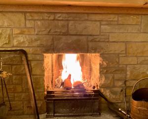 a brick fireplace with a fire in it at Romantic luxury Cottage right next to the ocean in Saint Abbs