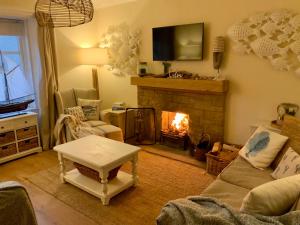 a living room with a fireplace and a couch at Romantic luxury Cottage right next to the ocean in Saint Abbs