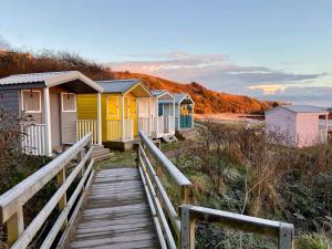 a row of colourful beach huts on a wooden boardwalk at Romantic luxury Cottage right next to the ocean in Saint Abbs