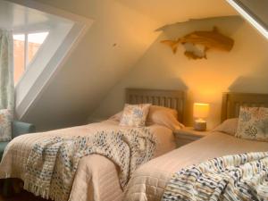 a attic bedroom with two beds and a window at Romantic luxury Cottage right next to the ocean in Saint Abbs