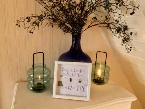 a vase with flowers and candles on a shelf at Romantic luxury Cottage right next to the ocean in Saint Abbs