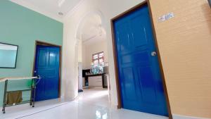 two blue doors in a hallway with a table at PCB Homestay in Kota Bharu
