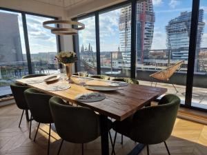 a dining room with a table and chairs and a large window at Luxury Penthouse Rzeszów in Rzeszów