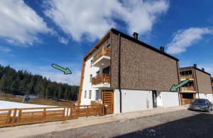 une maison avec deux cerfs-volants verts volant dans les airs dans l'établissement Apartman Green - Ravna planina, à Pale