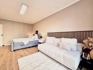 sala de estar con 2 camas y sofá en BaMo Studio - modern living lakeside, en Klagenfurt
