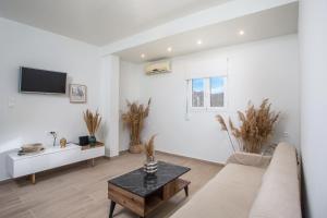 biały salon z kanapą i stołem w obiekcie Stegna Paradise View w mieście Archangelos