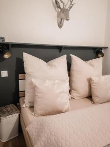 a bed with white pillows and a clock on the wall at Ferienhaus zur Weinfee in Briedel +43 photos