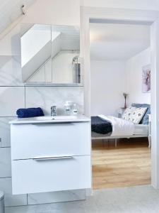 baño blanco con lavabo y cama en 2 appartement entier 3 pièces, 2 chambres, idéal famille et travail, parking gratuit, en Mulhouse