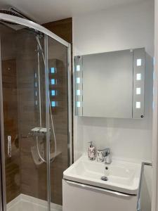 a white bathroom with a sink and a shower at Cosy Detached Annexe With Free Off Street Parking in Milton Keynes