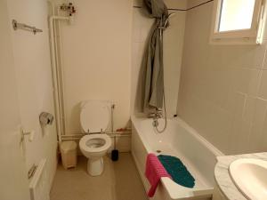 a bathroom with a toilet and a tub and a sink at Studio proche des thermes en rez-de-chaussée avec place de parking in Bagnères-de-Bigorre
