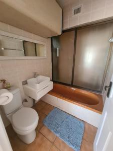 a bathroom with a toilet and a sink and a shower at Uvongo cabanas in Margate