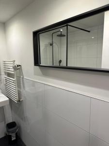 uma casa de banho branca com um espelho e um lavatório em 44qm Apartment in Pempelfort em Dusseldorf