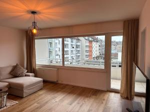 uma sala de estar com uma grande janela e um sofá em 44qm Apartment in Pempelfort em Dusseldorf