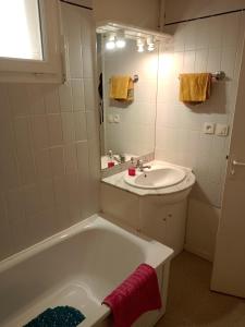 a bathroom with a white tub and a sink at Studio proche des thermes en rez-de-chaussée avec place de parking in Bagnères-de-Bigorre