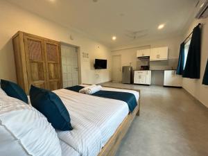 a bedroom with a large bed and a kitchen at Serenova by Dia Hotels in Calangute