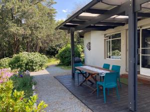 una terraza de madera con mesa y sillas en una casa en Bramber Cottage Hogsback, Living With Joy!, en Hogsback