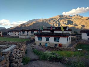 un grupo de casas con una montaña en el fondo en Nizer khangchung Homestay, en Mani