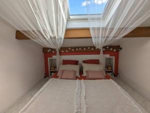 une chambre avec un grand lit avec une lucarne dans l'établissement Studio pour 2 à 10min de la mer, à Saint-Nazaire