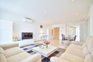 a living room with white furniture and a table at WIOLA SeaView Apartment by MOJE Holiday in Lagos