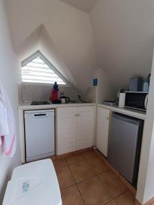 a small kitchen with white cabinets and a window at Appartement Madinina 6 personnes vue sur mer dans village vacances in Sainte-Luce