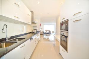 a white kitchen with a sink and a stove at WIOLA SeaView Apartment by MOJE Holiday in Lagos