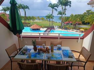 a table and chairs with a view of a pool at Appartement Madinina 6 personnes vue sur mer dans village vacances in Sainte-Luce