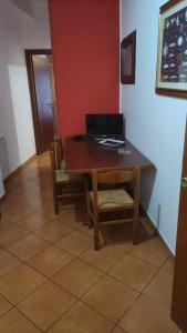 una mesa y sillas en una habitación con una pared roja en IL PORTICCIOLO Apartment - Via Umberto 25, en Giardini Naxos