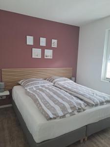 a bed in a bedroom with a red wall at Ferienhaus Spreewaldliebe in Lübben