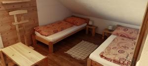 Cette petite chambre comprend deux lits et une table. dans l'établissement DREVENÁ CHALÚPKA Slovenský raj HRABUŠICE, à Hrabušice