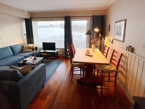 a living room with a table and a blue couch at Apartment HOVDEN II in Hovden