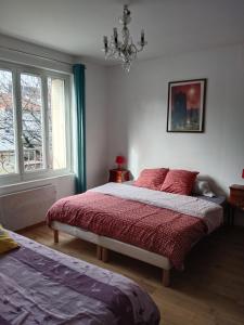 sypialnia z 2 łóżkami i żyrandolem w obiekcie Andrea w mieście Fontenay-sous-Bois