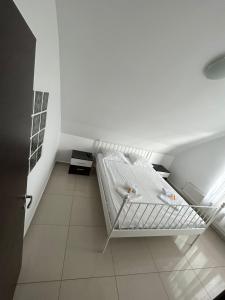 um quarto branco com uma cama num quarto em Chez Ana em Otopeni
