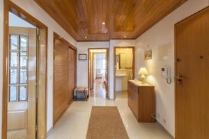 - un couloir avec une salle de bains pourvue d'un lavabo et d'un miroir dans l'établissement FLH Parede Family Flat with Balcony, à Parede