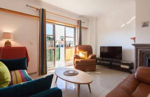 een woonkamer met een bank, een stoel en een televisie bij FLH Parede Family Flat with Balcony in Parede